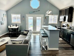 Open Living room and full kitchen. View of deck, backyard, dock and water