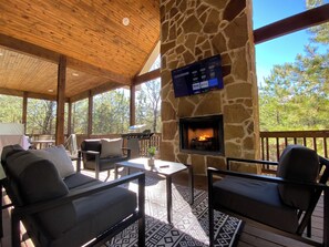 Cozy patio with fireplace, TV, and comfy seating to relax in nature