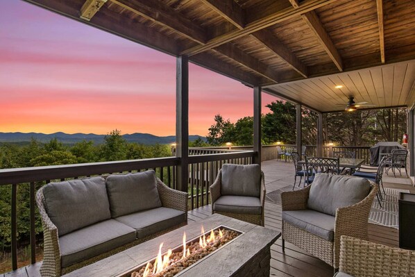 Enjoy the deck’s comfort with its outdoor furniture and fire pit, all while taking in panoramic mountain views. The sunset adds a warm, peaceful glow, casting long shadows and creating a perfect retreat