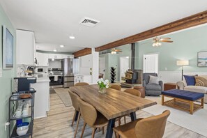 Open-concept living and dining area with modern kitchen and wood-burning stove. Perfect for relaxing and entertaining. 🍽️🔥🛋️