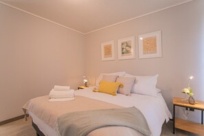Relax in this serene bedroom with plush bedding, soft lighting, and charming decor—your perfect retreat after a day of adventure.