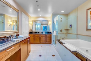 Luxury bathroom with deep soaking tub, glass shower, and dual vanities.
