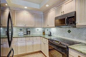 Cook in the fully-equipped modern kitchen, featuring stainless steel appliances, granite countertops, and ample cabinetry for all your culinary needs.