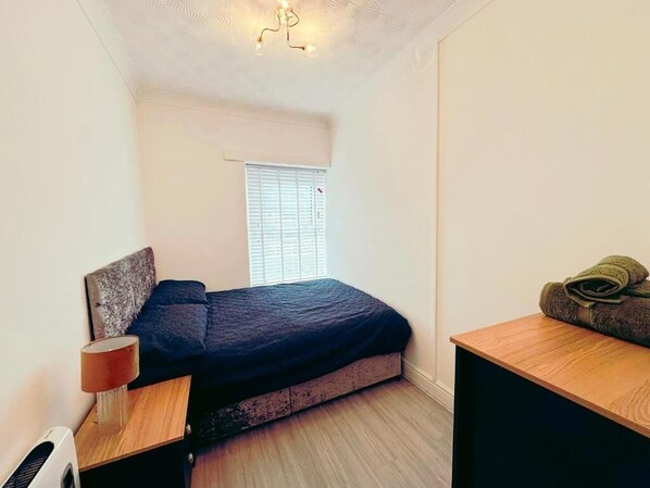 This comfortable room offers a comfortable bed with soft linens and warm lighting, creating a peaceful atmosphere.