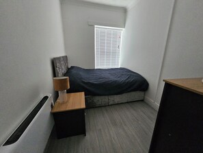This comfortable room offers a comfortable bed with soft linens and warm lighting, creating a peaceful atmosphere. 