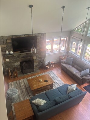 Ample seating for guests around the wood burning fireplace with vaulted ceilings