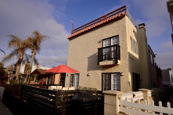 Front of House with deck furniture, outside dining and gas barbecue