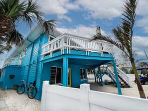 The front of the house features a spacious wraparound deck and ample parking for five cars, plus a golf cart.