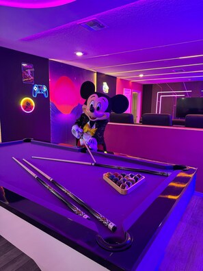 Neon-lit game room with pool, arcade vibes & magical surprises!