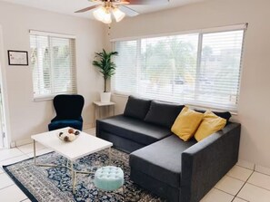 Welcome to our haven! The entrance unveils a cozy ambiance with a plush couch, an inviting chair, and a chic center table—a perfect spot for shared moments. The smart TV adds entertainment to the warm welcome, creating a stylish and comfortable entry