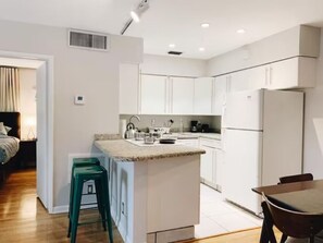 Savor the essence of culinary delight in our kitchen, seamlessly flowing into the dining room. A charming table for four awaits, where every meal becomes a shared moment in a space designed for warmth and connection