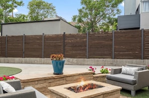Enjoy a large fire pit surrounded by comfortable outdoor seating, perfect for cozy evenings and social gatherings.