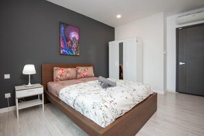 A bedroom with a queen sized bed and plush pillows.