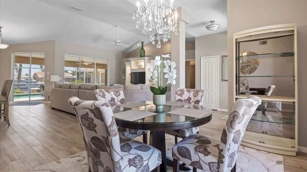 "Bright dining area with stylish furnishings and chandelier."
