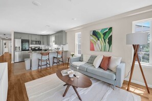 Cozy, warmly lit living room with stylish and elegant decor, smart TV, and balcony access for a relaxing vibe.