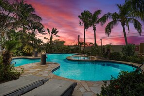 - Tropical villa pool at sunset, surrounded by lush palm trees and vibrant foliage - Serene outdoor oasis with glowing water and cozy lounging spots - Perfect for unwinding, the setting combines natural beauty with a tranquil atmosphere