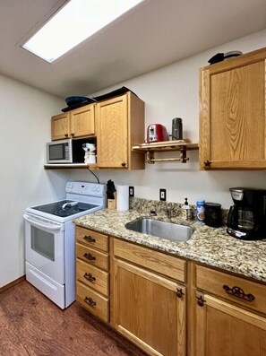 Kitchen with electric stove and microwave