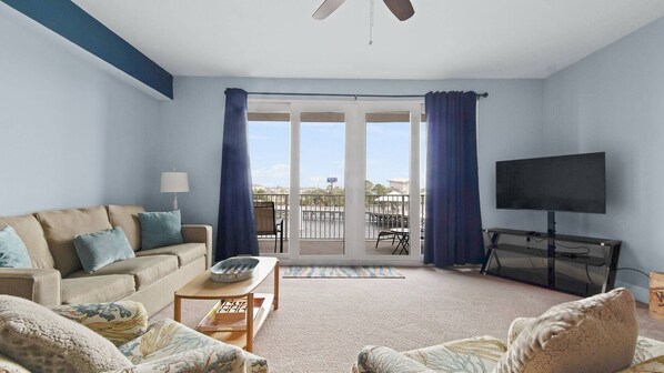 Living room with queen size sleeper sofa (sleeps 2) and access to balcony.