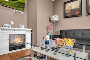 Livingroom with an electric fireplace and large smart TV.