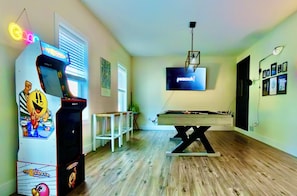 Game room with pool table, Pac-Man, darts & 65" TV for movies and sports.