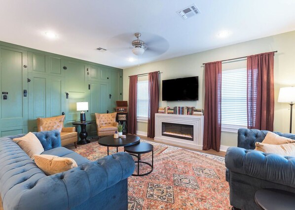 The living room features a record player, electric fireplace and a feature wall.
