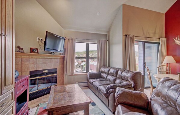 Relax in the inviting living room, featuring a cozy fireplace and comfortable seating.