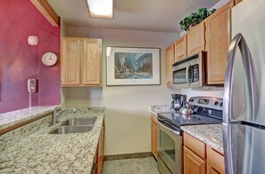 Cook in the modern kitchen, boasting stainless steel appliances, granite countertops, and plenty of cabinet space for all your culinary needs.