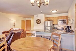 Enjoy meals in the fully equipped kitchen and dining area, complete with modern appliances, a dining table, and stylish decor.