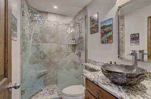 Luxurious bathroom with a walk-in shower, elegant stone countertop, and modern fixtures.