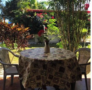 Outdoor table and chairs off of cottage patio.