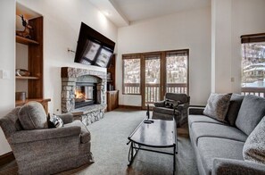 Relax in the cozy living room, equipped with a warm fireplace, comfortable seating, and a large flat-screen TV for your entertainment.