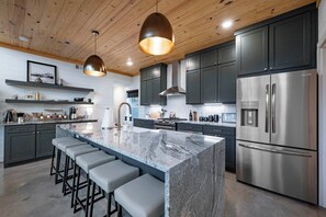 Spacious and fully stocked kitchen with barstool seating for 6