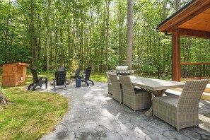 The expansive patio offers a private hot tub, fire pit, dining area, and gas grill.