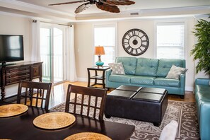 Another view of the living area with access to covered balcony and large screen 