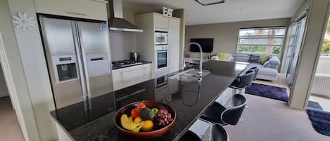 Large granite bench top, gas hob, wall oven, double door fridge with icemaker
