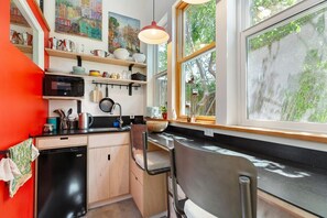 The studio kitchenette has a mini fridge, microwave, induction cooktop (in the drawer) and a full sink. The dining counter seats two and looks out into the garden.