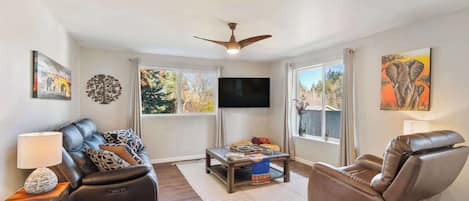 Relax in the living room with reclining leather seating, a big-screen TV, and beautiful views of the surrounding neighborhood.