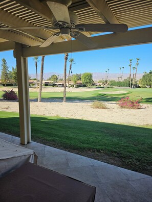 View from back patio , 2 outdoor fans, nice seating areas and gas grill.