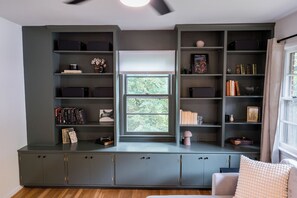 The green bookshelf and large picture window are centerpieces of the living room