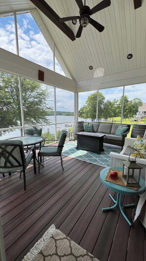 Eat-in screened in porch with comfy couch and glider overlooking the lake