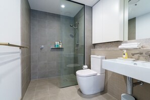 The bathroom features a stylish design paired with functional elements, making it a perfect space for both relaxation and convenience.