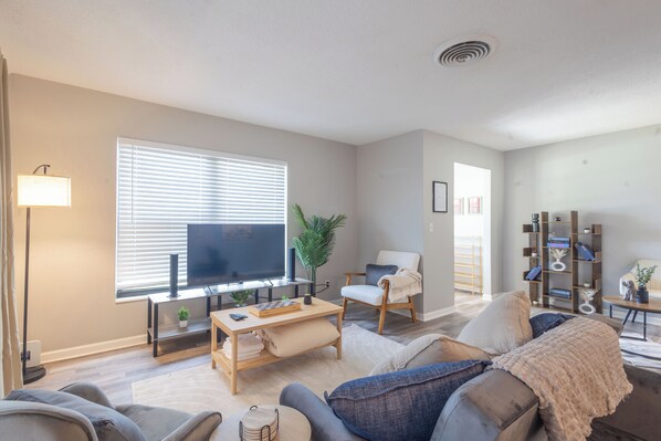 Living room with flat inch tv, sofa bed, and sound bar