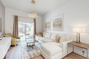 The living room exuded warmth and charm, featuring a plush sofa nestled between two elegant armchairs, creating a cozy and inviting atmosphere.