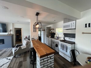 Fully stocked kitchen w/ coffee station, microwave, electric stove, refrigerator