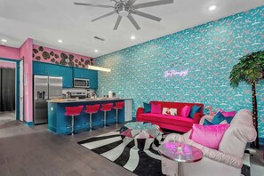 Welcome to the Flamingle House living room—where vibrant pinks and turquoise meet cozy comfort and stylish charm.