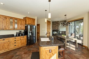 Gourmet kitchen with mountain views at The Sanctuary. Rustic charm meets modern luxury. Granite counters, stainless appliances, and cozy fireplace. Perfect for family meals or entertaining. Close to downtown Prescott, sleeps 16