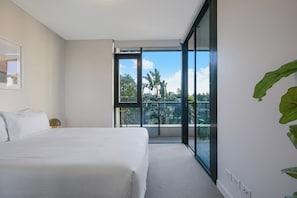 The primary bedroom is set with a queen-sized bed and comes with large, mirrored wardrobes for storing your belongings. It also offers direct access to the balcony, seamlessly blending indoor comfort with outdoor relaxation.
