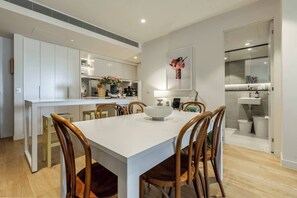 Beautiful and bright kitchen & dining area has a 6-person dining table, bar seating and crisp design