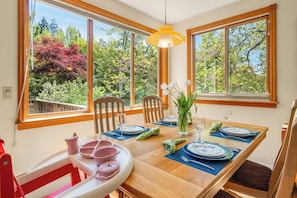 Bright dining space with lush garden views—plus a high chair for the little one.