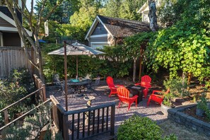 Backyard oasis with multiple seating arrangements, string lights and a fountain